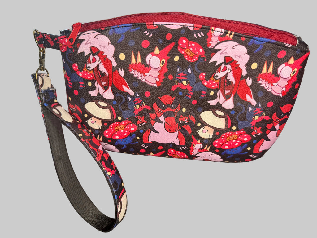 Wristlet with colorful character design on a dark surface
