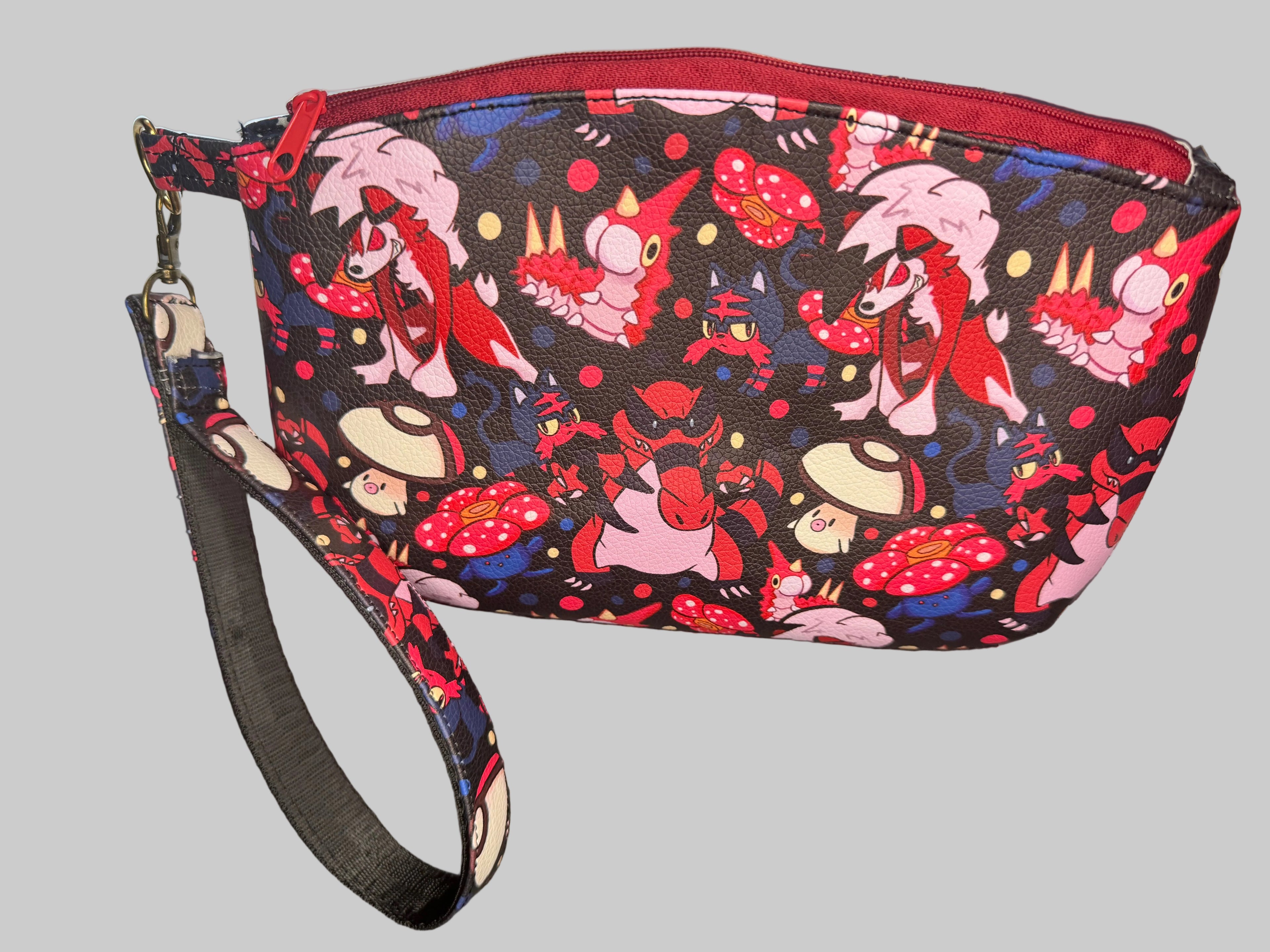 Wristlet with colorful character design on a dark surface
