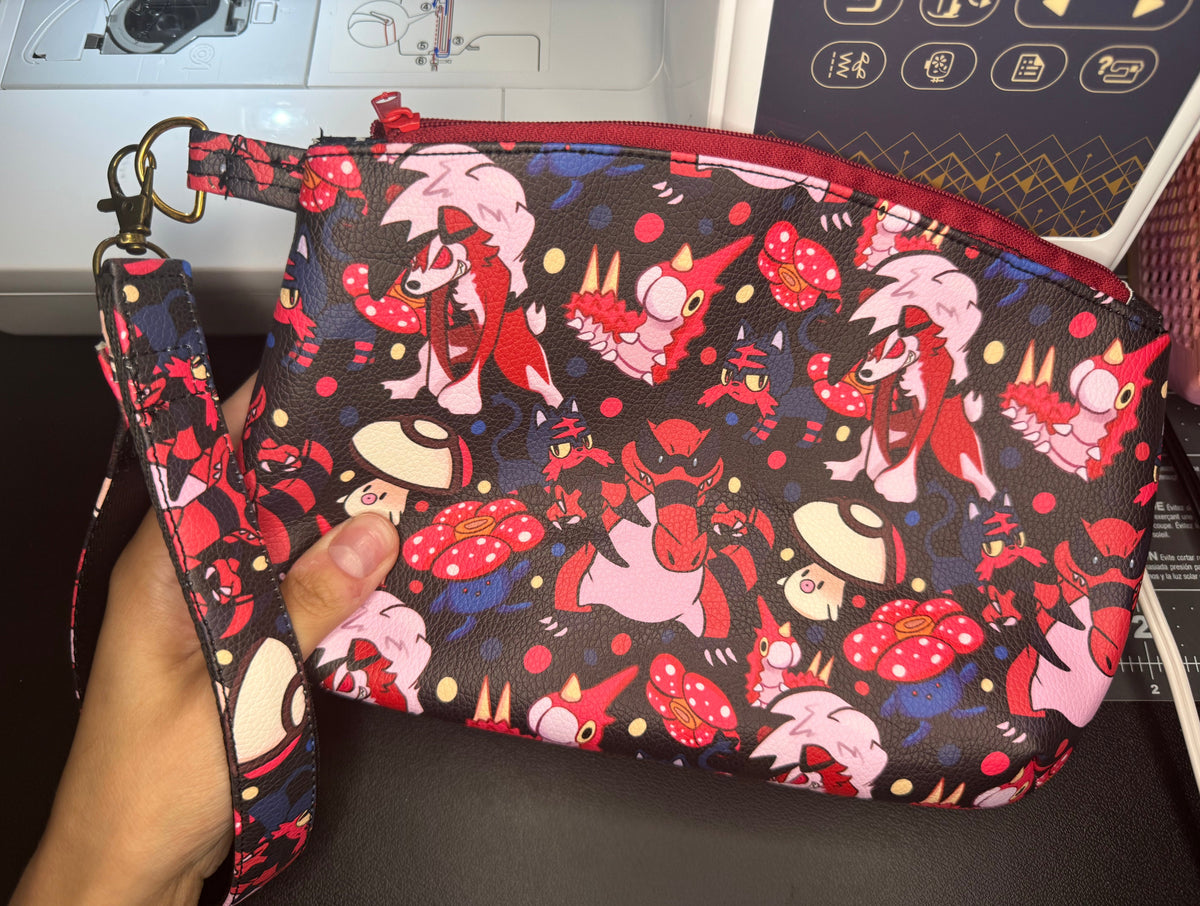 Pouch with cartoon character design held by a hand, with sewing machine in the background