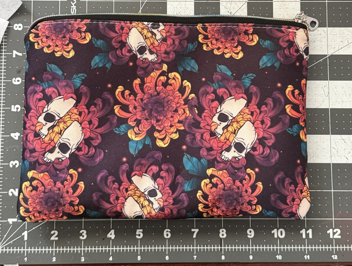 Skull chrysanthemum pouch next to a ruler